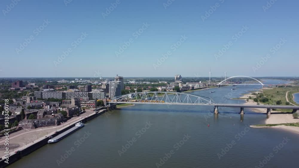 Railroad Bridge with yellow train over river Waal in Nijmegen, The Netherlands, Aerial Railroad Bridge with yellow train over river Waal in Nijmegen, The Netherlands, Aerial