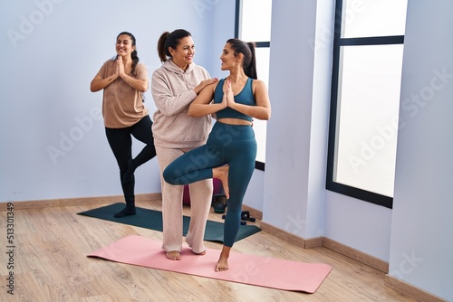 Three woman wearing sportswear training yoga at sport center