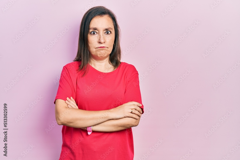 Middle age hispanic woman wearing casual clothes skeptic and nervous, disapproving expression on face with crossed arms. negative person. Middle age hispanic woman wearing casual clothes skeptic and nervous, disapproving expression on face with crossed arms. negative person.