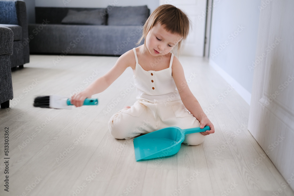 Cute European child with blue scoop for garbage and brush for sweeping floor helps to clean, help around house toddlers, development of Montessori Cute European child with blue scoop for garbage and brush for sweeping floor helps to clean, help around house toddlers, development of Montessori
