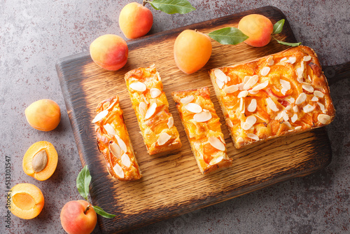 Foto Summer fresh apricot pie with almonds close-up on a wooden board on the table