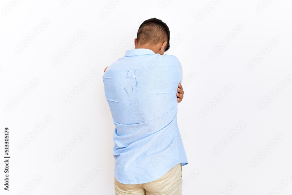 Young hispanic man wearing business shirt standing over isolated background hugging oneself happy and positive from backwards. self love and self care Young hispanic man wearing business shirt standing over isolated background hugging oneself happy and positive from backwards. self love and self care