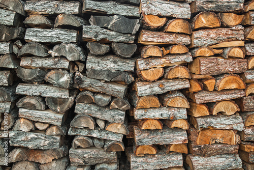 Woodpile. Textured firewood background. Pile of old dry chopped fire wood 