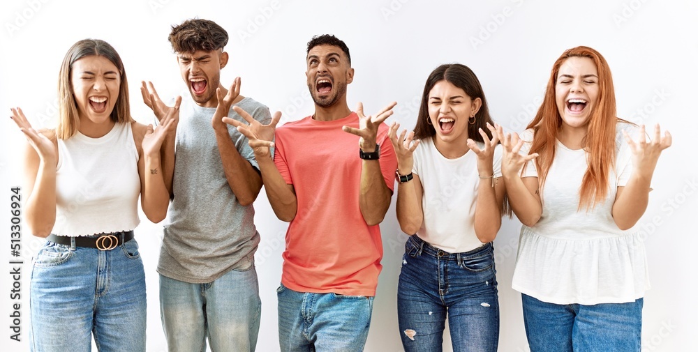 Group of young friends standing together over isolated background celebrating mad and crazy for success with arms raised and closed eyes screaming excited. winner concept Group of young friends standing together over isolated background celebrating mad and crazy for success with arms raised and closed eyes screaming excited. winner concept