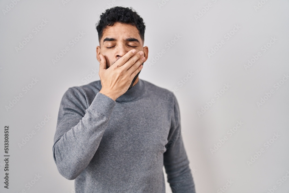 Hispanic man with beard standing over white background bored yawning tired covering mouth with hand. restless and sleepiness. Hispanic man with beard standing over white background bored yawning tired covering mouth with hand. restless and sleepiness.