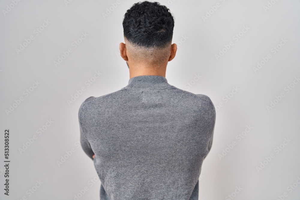 Hispanic man with beard standing over white background standing backwards looking away with crossed arms Hispanic man with beard standing over white background standing backwards looking away with crossed arms
