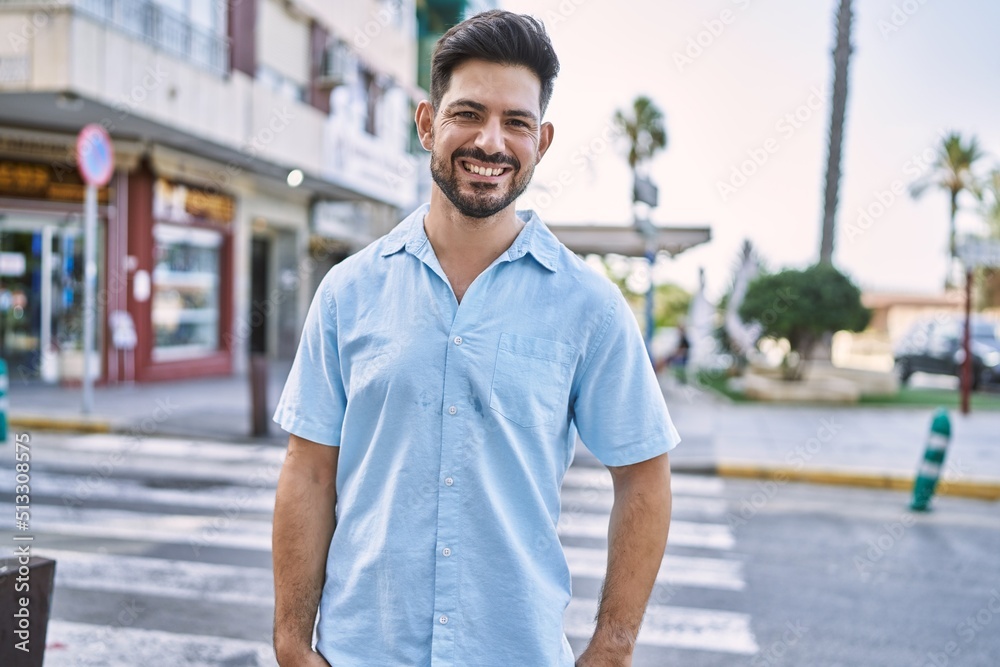 Fototapeta premium Young hispanic man smiling happy standing at the city.