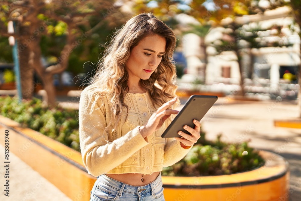 Obraz premium Young woman using touchpad at park