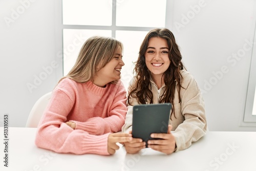 Young couple smiling happy using touchpad at home.