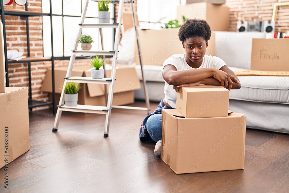 African american woman sitting on the floor at new home skeptic and nervous, frowning upset because of problem. negative person. African american woman sitting on the floor at new home skeptic and nervous, frowning upset because of problem. negative person.