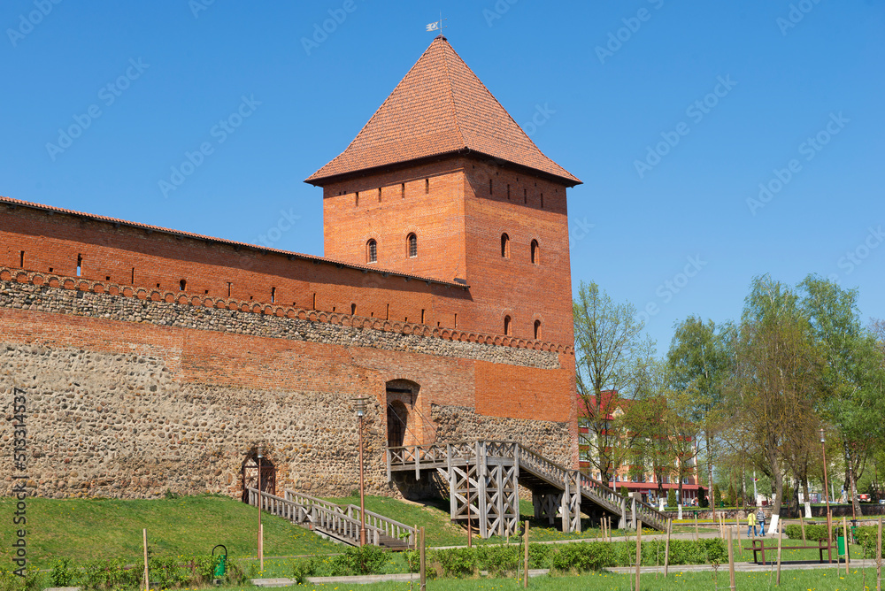 Fragment of the wall and defensive tower of the Lida Castle on a sunny April day. Lida, Belarus