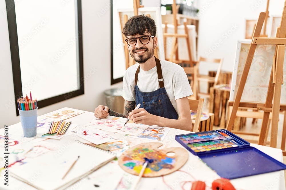 Naklejka premium Young hispanic artist man smiling happy drawing at art studio.