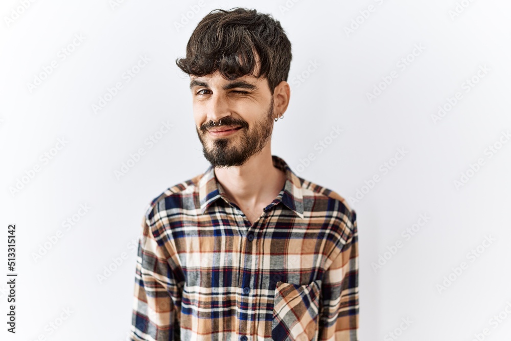 Hispanic man with beard standing over isolated background winking looking at the camera with sexy expression, cheerful and happy face. Hispanic man with beard standing over isolated background winking looking at the camera with sexy expression, cheerful and happy face.