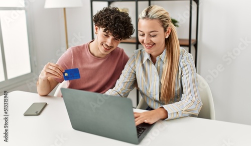 Young couple buying using laptop and credit card at home.