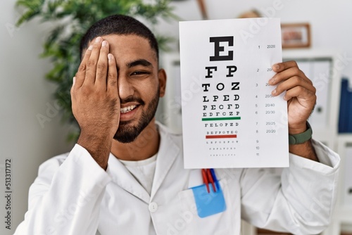 Young arab man holding sneller test at clinic photo
