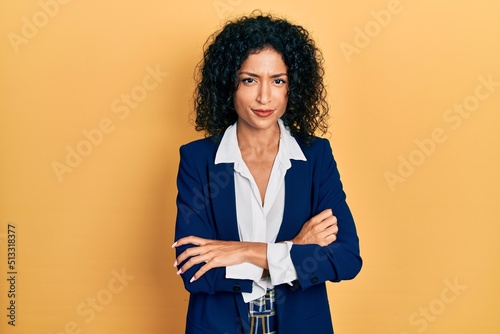 Young latin girl wearing business clothes skeptic and nervous, disapproving expression on face with crossed arms. negative person.