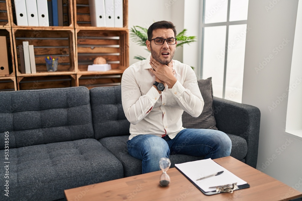 Young hispanic man with beard working at consultation office shouting suffocate because painful strangle. health problem. asphyxiate and suicide concept. Young hispanic man with beard working at consultation office shouting suffocate because painful strangle. health problem. asphyxiate and suicide concept.