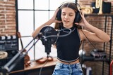 Adorable girl artist singing song at music studio