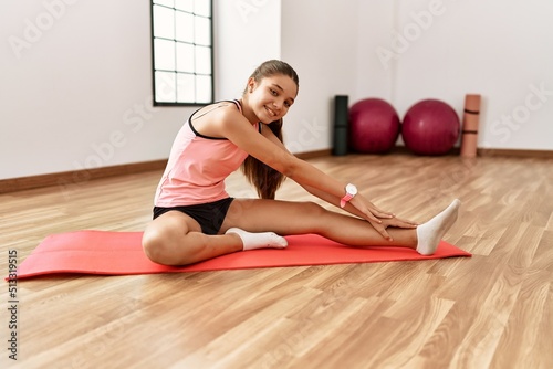 Adorable girl smiling confident stretching at sport center