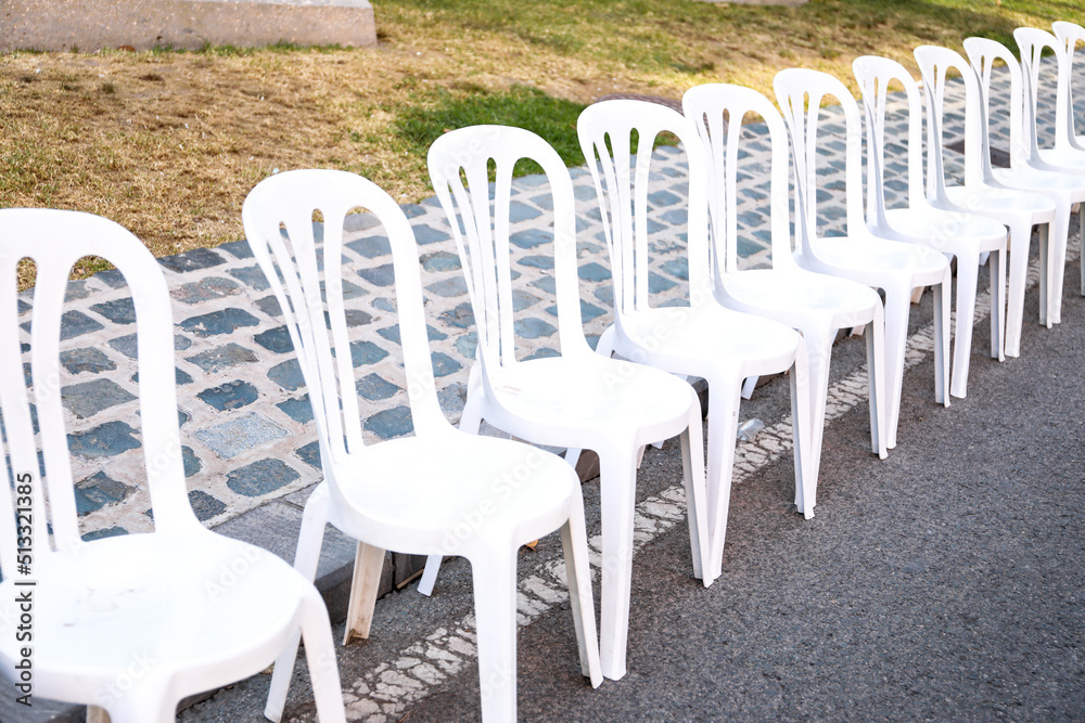 Photos of plastic chairs placed in the street, so that people can sit and watch the parade of the Alicante's fogueres festivities.