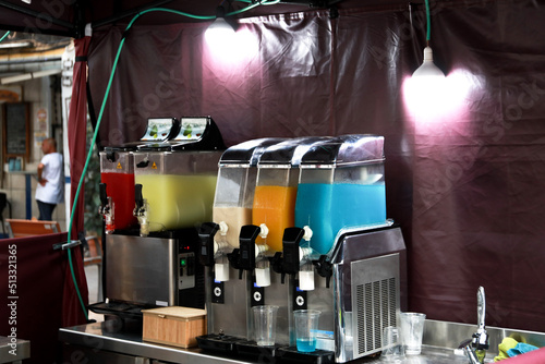 Stall with different flavors of slushies at the street market of Alicante's fogueres festivities. photo