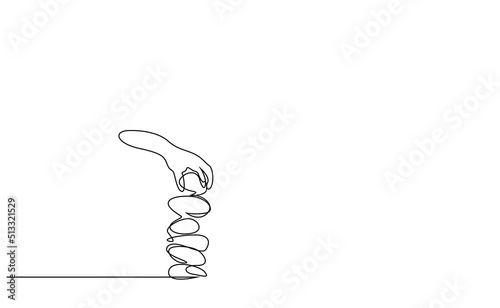 a person who balances stones on top of each other puts another stone on top