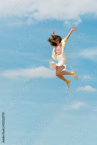 Girl flies in the sky raising her hands. Concept of freedom and happiness. Young woman jumping through the air.