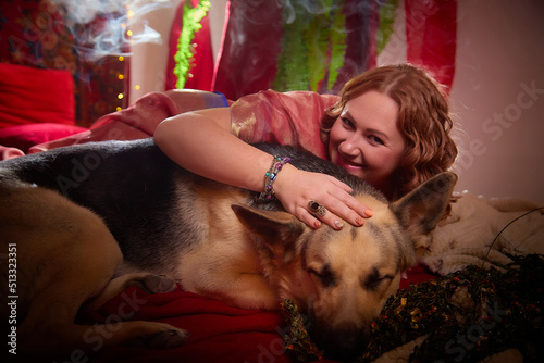 Photography A beautiful European girl looking like an Arab woman in a red room in a harem with big dog