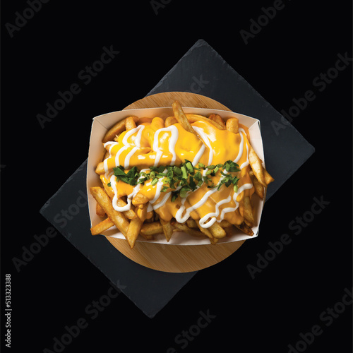 Photography Loaded Cheese Fries served in a box isolated on wooden board top view on black b