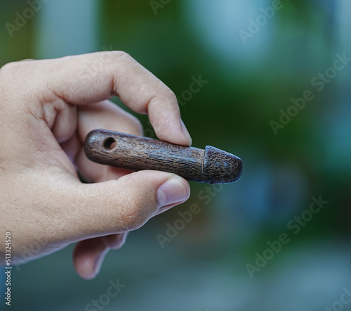 selective focus Wooden image of penis in hand and amulet of thailand