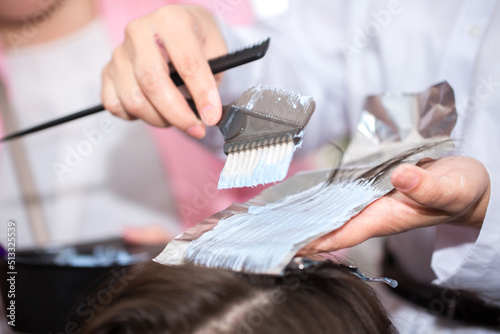 Hairdresser stylist takes care of girl's hair. Hair care procedures in a beauty salon. Hair treatment, coloring and styling. Botox and hair lamination keratin straightening.