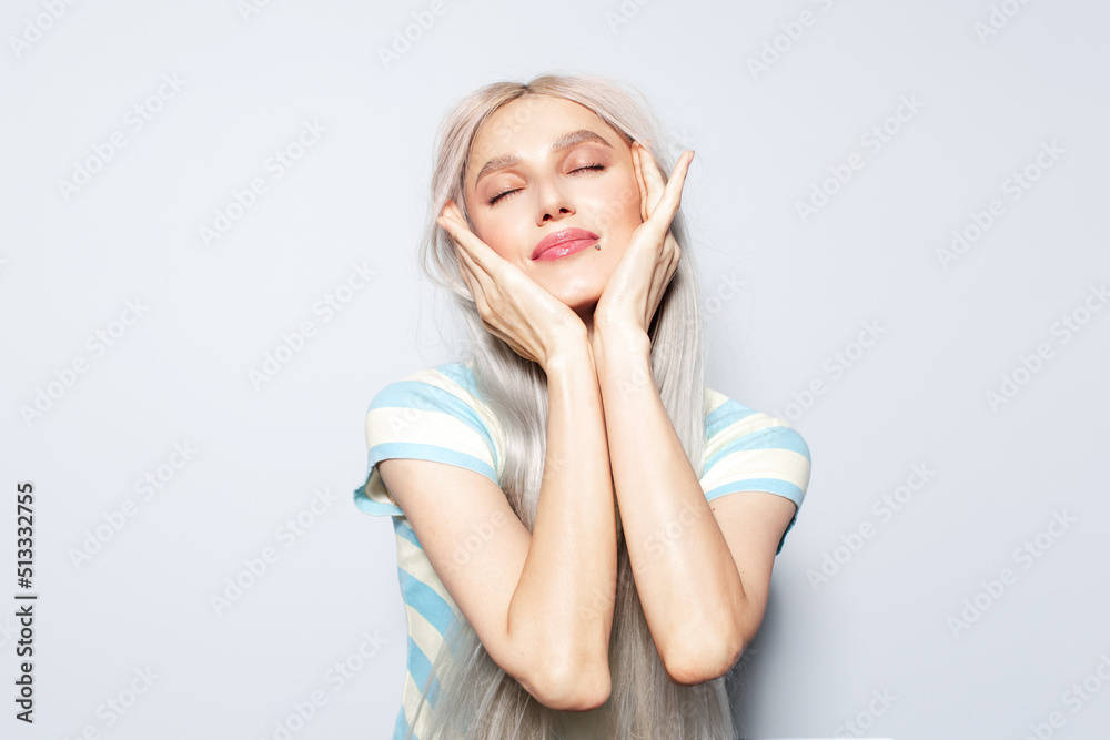 Portrait of beautiful blonde girl holding hands on face, on white background. Portrait of beautiful blonde girl holding hands on face, on white background.