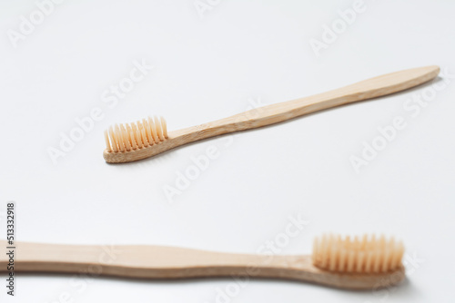 Close-up of two bamboo toothbrushes on white background. Top view.