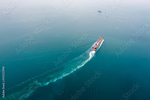 container ship sailing full speed to transport goods in containers for import export internationally and worldwide, business services transportation by container ship open sea, photograph aerial view © SHUTTER DIN