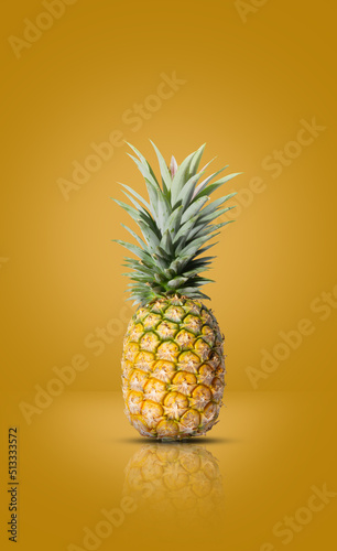yellow pineapple mixed with green put on a orange background The perfect fruit for a summer at the beach.