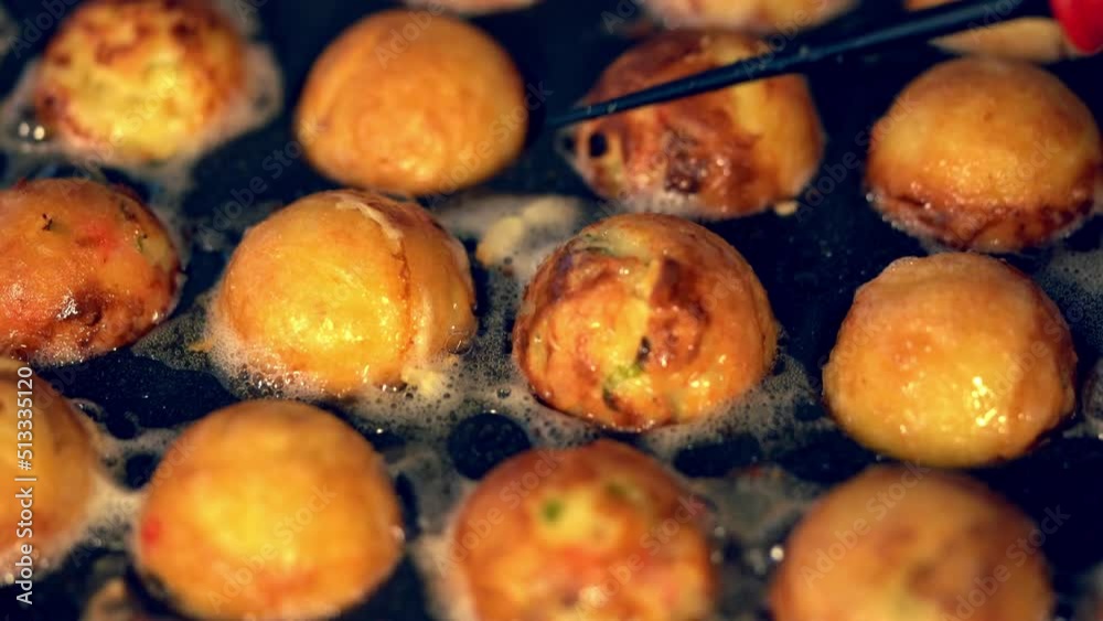 油で揚げられるようにカリカリに焼かれるたこ焼きの動画 油で揚げられるようにカリカリに焼かれるたこ焼きの動画