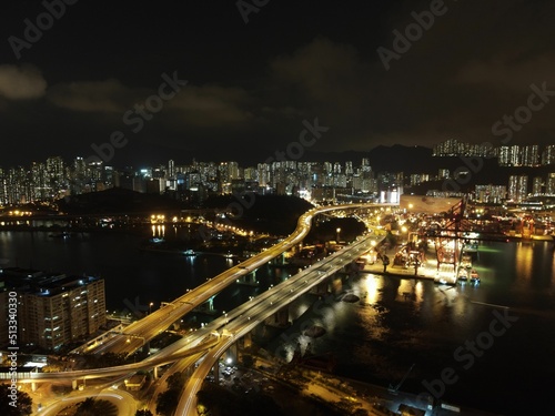 Aerial shot of dense coastline buildings with illuminated lights at nightin Hong Kong photo