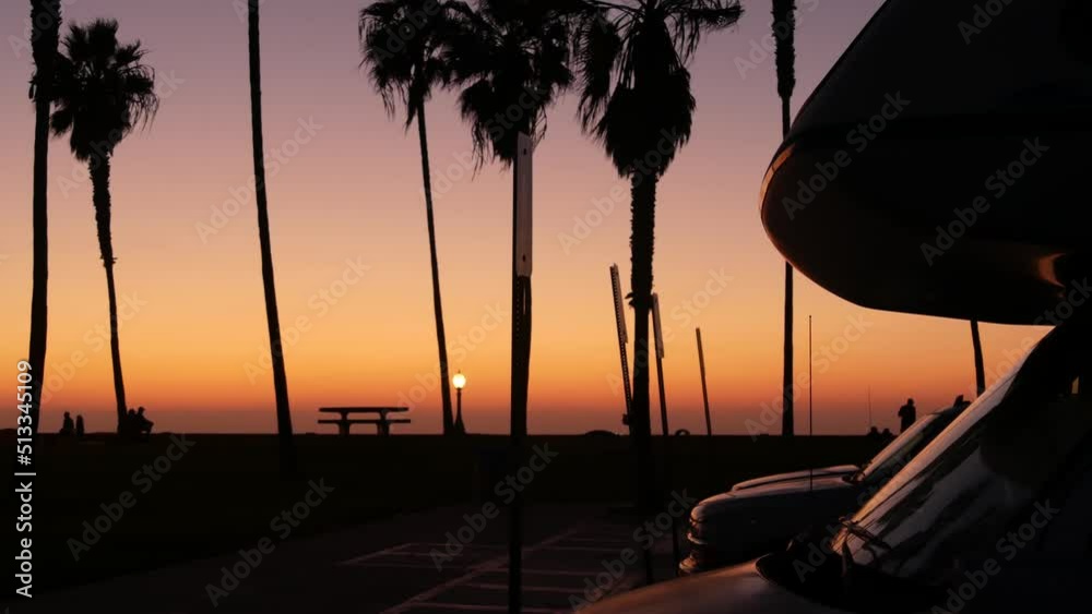 Motorhome trailer, caravan for road trip, palm trees on beach at sunset, California coast, USA. Camper van RV motor home in beachfront park at sundown, San Diego, Mission beach. Mobile home campervan.