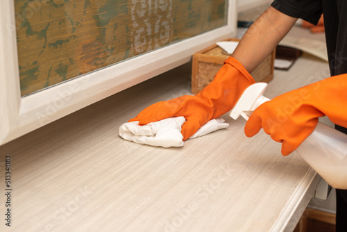 Housemaid use grove orange cleaning table in hotel room with Spray 
