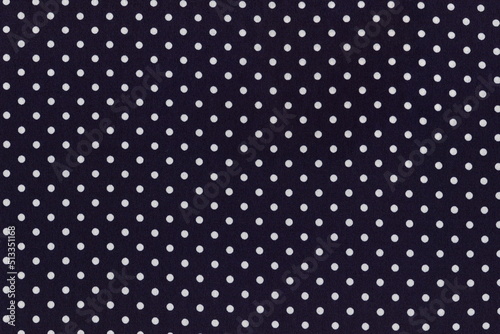 Natural light silk fabric of very dark blue color with small white polka dots. Royal polka dot material. The background is a simple but elegant fabric.