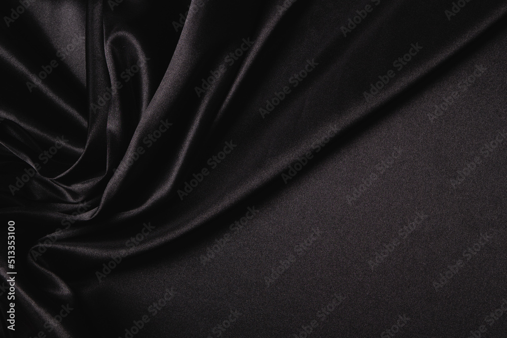 Obraz premium Abstract monochrome elegant luxury cloth background. Black color background with drapery and wavy folds of luxurious silk satin material. Top view