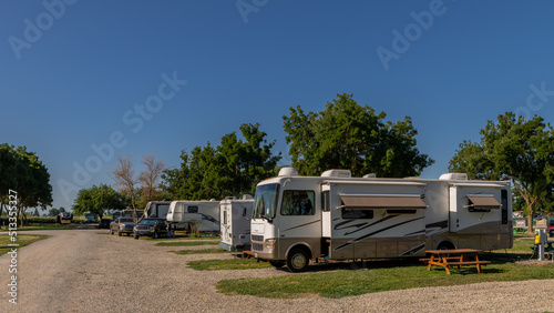 Rv campers at campsites on a sunny morning with blue skies