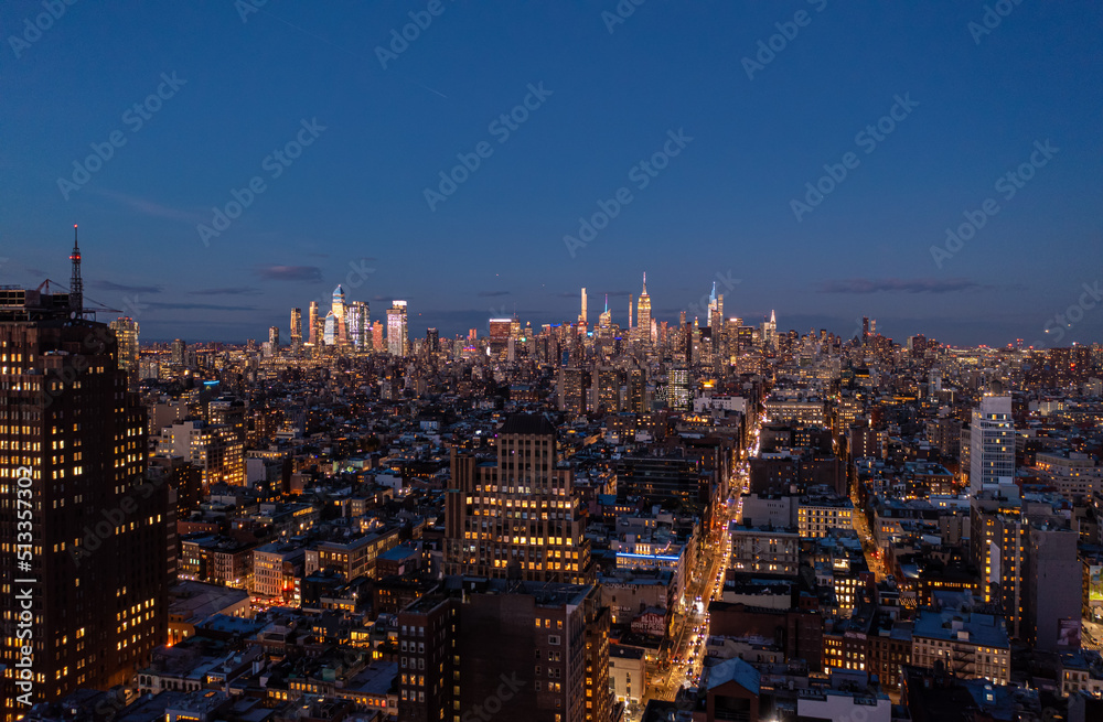 Panoramic shot of metropolis after sunset. Tops of downtown skyscrapers lit by last rays of sun. Manhattan, New York City, USA