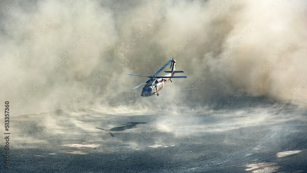 Military Black Hawk helicopter landing or taking off in dramatic clouds of dust - obrazy, fototapety, plakaty 