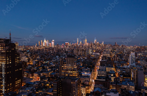 Panoramic shot of metropolis after sunset. Tops of downtown skyscrapers lit by last rays of sun. Manhattan, New York City, USA © 21AERIALS