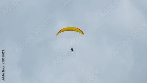 A handheld and follow focus with noise effect of flying paragliders in Interlaken before raining.