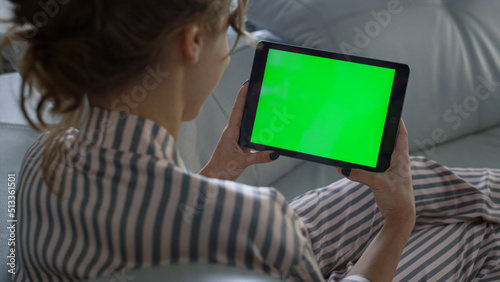 Teenager holding chroma key tablet computer in hands closeup. Girl rest on sofa