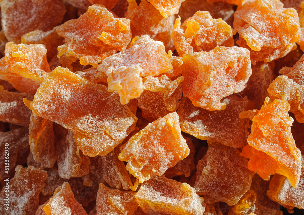 Background of pieces of candied pumpkin sprinkled with powdered sugar Background of pieces of candied pumpkin sprinkled with powdered sugar