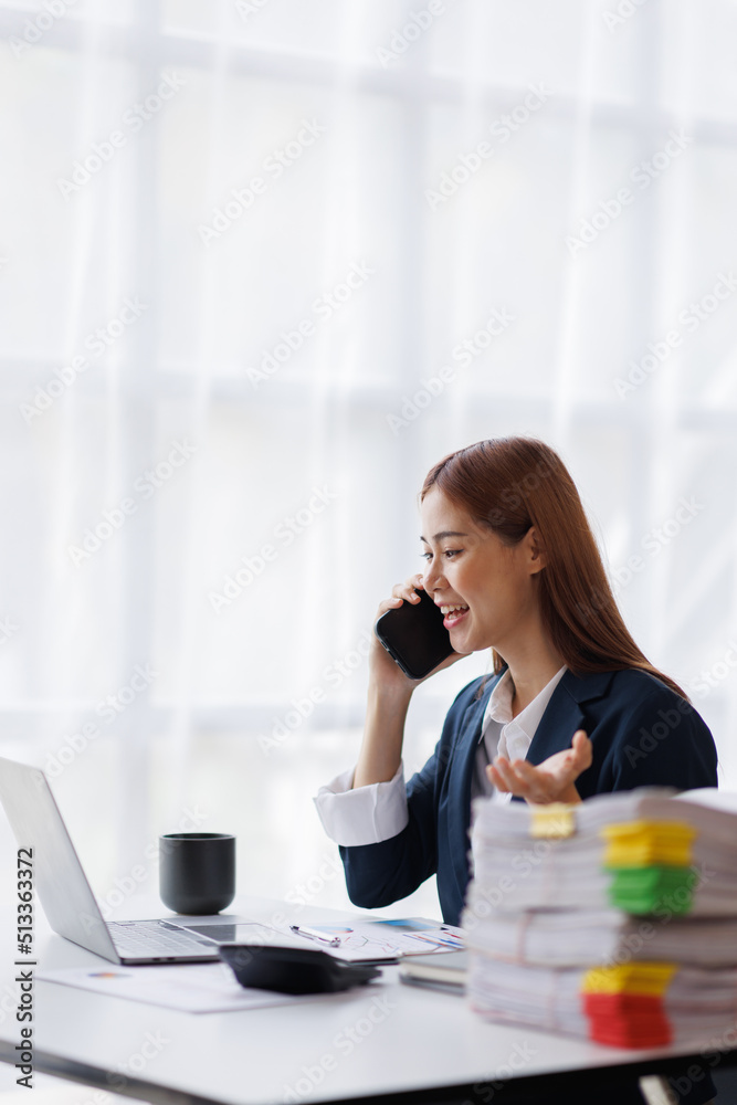 Asian businesswoman talking on phone, using laptop, looking at screen, entrepreneur manager consulting client by call, looking at computer screen, discussing project, reading information Asian businesswoman talking on phone, using laptop, looking at screen, entrepreneur manager consulting client by call, looking at computer screen, discussing project, reading information