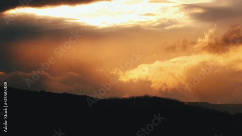 Scenic view of mountains under the bright sunlight beaming through dense gloomy clouds